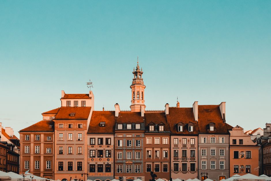 Picturesque view of historic old town buildings and tower in Warsaw under clear sky.