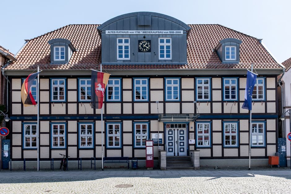 Historic timbered town hall in Dannenberg, Germany, sunny day, flags displayed.