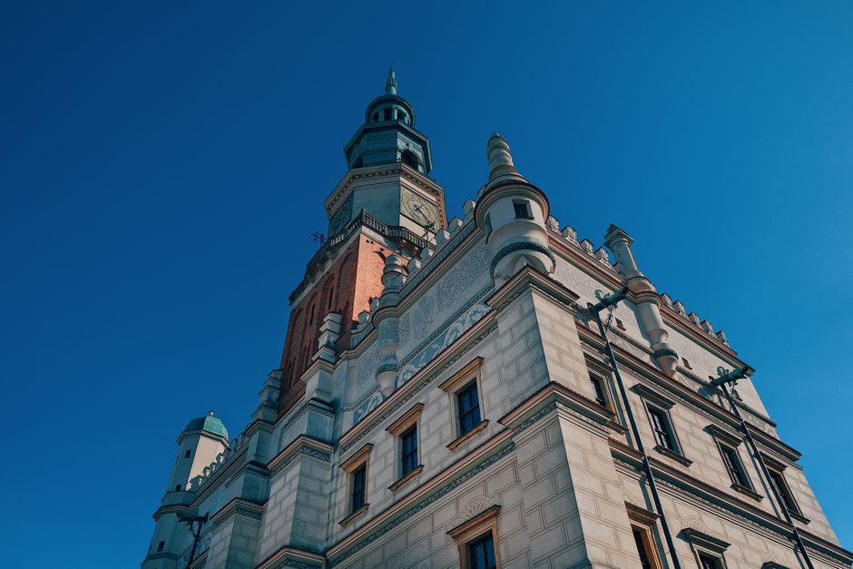 Low-angle shot of the historic town hall tower in Poznań against a clear blue sky.